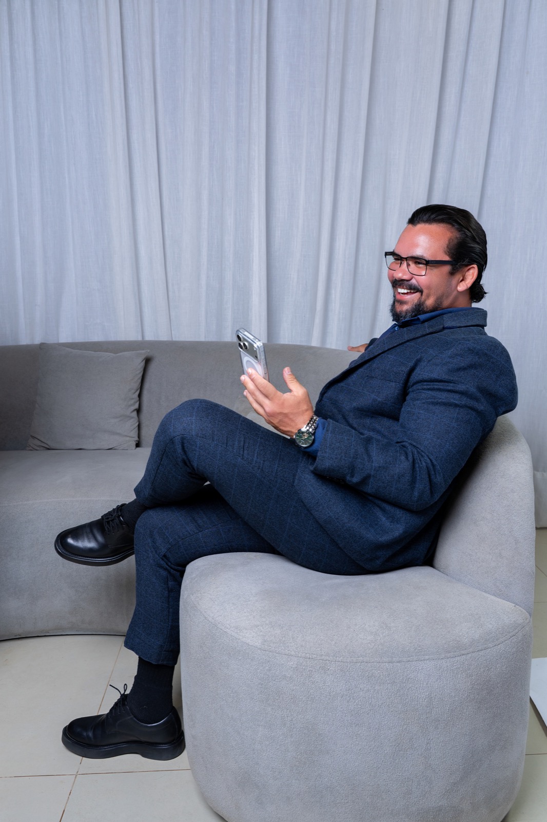 Dr. Ronney Menezes sentado em um sofá, sorrindo